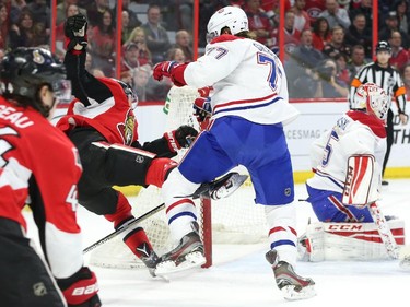 Tom Gilbert of the Montreal Canadiens hits Curtis Lazar of the Ottawa Senators during first period NHL action.