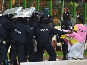 Ghana's national football team players leave the pitch protected by riot police at the half-time of the 2015 African Cup of Nations semi-final football match between Equatorial Guinea and Ghana in Malabo, on February 5, 2015.