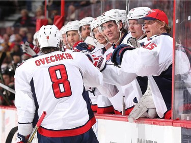 Alex Ovechkin #8 of the Washington Capitals celebrates his second period goal against the Ottawa Senators with teammates at the players' bench.
