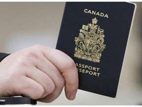 A passenger holds his Canadian passport before boarding a flight in Ottawa on Jan 23, 2007. THE CANADIAN PRESS/Tom Hanson