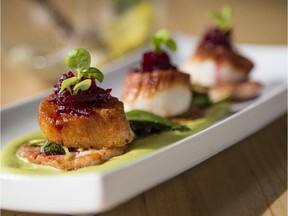 A plate of chef's choice scallops from Erling's Variety. The plate features smoked scallops, pea puree, house english bacon, stinging nettle, red miners lettuce and beet relish.