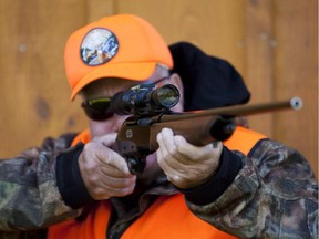 A rifle owner checks the sight of his rifle at a hunting camp property in rural Ontario west of Ottawa.