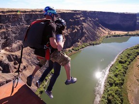 BASE jumpers make a tandem leap from the Perrine Bridge into the Snake River Canyon near Twin Falls, Idaho.