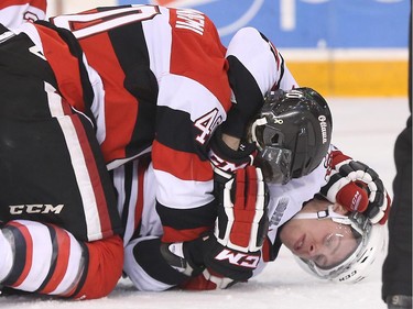 Alex Lintuniemi, left, of the Ottawa 67's fights against Carter Verhaeghe of the Niagara IceDogs during second period OHL action.