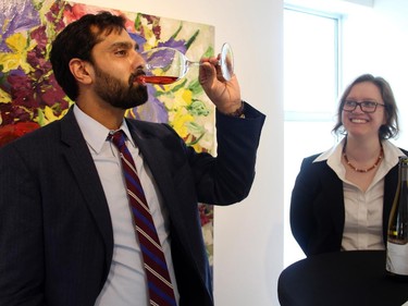 Amar Karrer tries a glass of Cave Spring wine from Niagara, served by volunteer Rutha Astravas, at An Evening of Wine, Food and Art, held at Koyman Galleries on Tuesday, March 24, 2015, in support of the Thirteen String Chamber Orchestra.