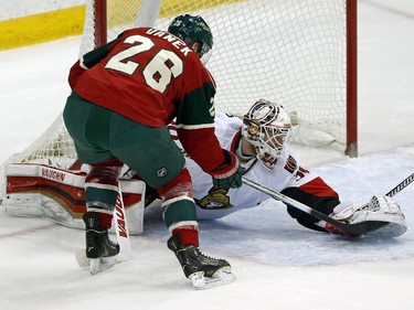 Ottawa Senators goalie Andrew Hammond stops a shot by Minnesota Wild's Thomas Vanek, left, of Austria, in the first period.