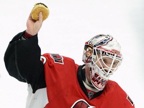 Ottawa Senators' Andrew Hammond, nicknamed 'The Hamburglar' holds up a hamburger after it was thrown on the ice after he defeated the Philadelphia Flyers 2-1 in the shootout in NHL hockey action in Ottawa on Sunday, March 15, 2015. THE CANADIAN PRESS/Sean Kilpatrick
