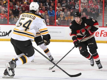 Bobby Ryan #6 of the Ottawa Senators skates up ice with the puck against Adam McQuaid #54 of the Boston Bruins.