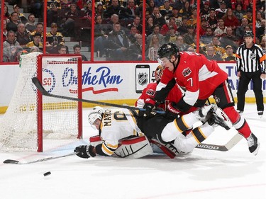 Brad Marchand #63 of the Boston Bruins falls on top of Craig Anderson #41 of the Ottawa Senators as Senators teammate Kyle Turris #7 tries to reach for the loose puck.