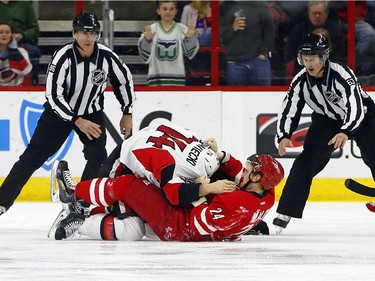 Carolina Hurricanes' Brad Malone (24) and Ottawa Senators' Mark Borowiecki (74) tussle during the first period.