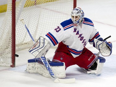 The puck rings off the post behind New York Rangers goalie Cam Talbot during first period NHL action.