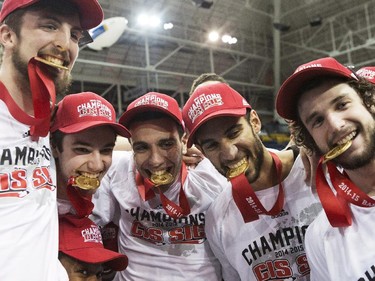 Members of the Carleton Ravens team (left to right) Cameron Smythe, Mitch Jackson, Victor Raso, Philip Scrubb and Gavin Resch pose with their gold medals in their teeth as they celebrate defeating the Ottawa Gee-Gees to win the CIS basketball final in Toronto on Sunday, March 15, 2015.