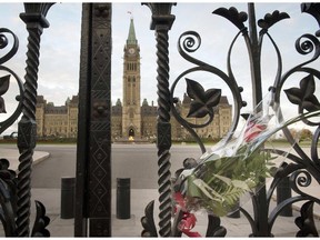 This October 23, 2014 file photo shows a bouquet of flowers attached to the Queen's Gates outside Canada's House of Parliament in Ottawa, one day after Michael Zehaf-Bibeau's shooting rampage in the nation's capital and Parliament buildings.