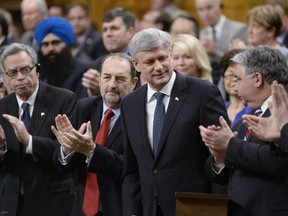 Canada Prime Minister Harper is applauded after introducing a motion in the House of Commons, Tuesday, March 24, 2015, in Ottawa, to expand and extend Canada's war against the Islamic State of Iraq and the Syria. Canada is expanding its military mission against the Islamic State group to include airstrikes on targets in Syria, Prime Minister Stephen Harper announced Tuesday.