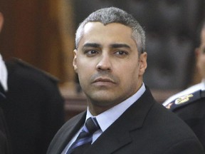 Canadian Al-Jazeera English journalist Mohamed Fahmy, speaks with policemen during his retrial in Cairo, Egypt, Monday, Feb. 23, 2015.