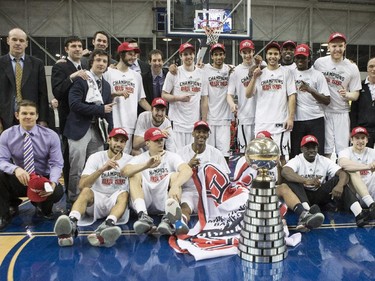 Carleton Ravens pose with the trophy after defeating the Ottawa Gee-Gees to win the CIS basketball final action in Toronto on Sunday, March 15, 2015.