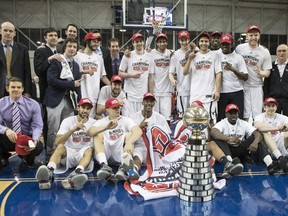 Carleton Ravens pose with the trophy after defeating the Ottawa Gee-Gees to win the CIS basketball final action in Toronto on Sunday, March 15, 2015.
