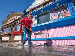 Chloe Gervais clears ice away from the front of Beavertails and Lois N' Frimas in the Byward Market on Wednesday.