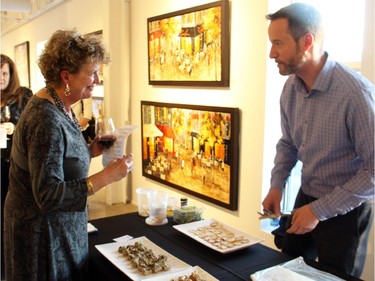 Clay Cardillo, director of operations for Beckta Dining & Wine and its sister restaurants, helped serve attendees of An Evening of Wine, Food and Art held Tuesday, March 24, 2015, at Koyman Galleries in support of Thirteen Strings Chamber Orchestra.