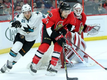 Cody Ceci takes control of the puck from behind Hammond's net.  Ottawa Senators (red) vs. San Jose Sharks at Canadian Tire Centre Monday, March 23, 2015.