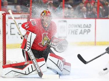 Craig Anderson of the Ottawa Senators is snowed by the Boston Bruins but still manages to make the save during second period NHL action.
