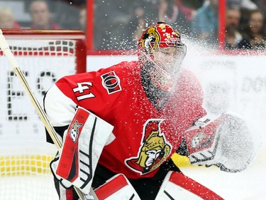 Craig Anderson  of the Ottawa Senators is snowed by the Boston Bruins but still manages to make the save during second period NHL action.