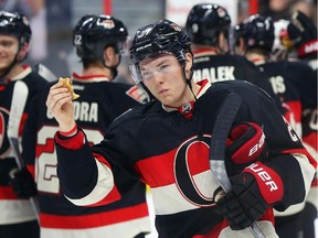 Curtis Lazar of the Ottawa Senators eats a burger that was thrown on the ice after his team's beat the Boston Bruins at Canadian Tire Centre in Ottawa, March 19, 2015.