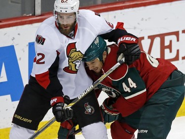 Ottawa Senators' Eric Gryba, left, and Minnesota Wild's Chris Stewart get tangled up in the first period.
