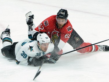 Ottawa Senators' Eric Gryba, right, falls to the ice defending against San Jose Sharks' Logan Couture during first period NHL hockey action.