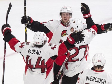 Ottawa Senators' Erik Condra, top, celebrates his goal against the Montreal Canadiens with teammates Jean-Gabriel Pageau, left, and Curtis Lazar during second period NHL hockey action.
