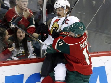 Ottawa Senators' Erik Karlsson, left, of Sweden, is hoisted off the ice on a check by Minnesota Wild's Zach Parise in the first period.