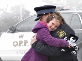 Publicity image for the OPP's 'community bear' program, in which officers hand out teddy bears to children in distress.