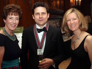 From left, Canadian author Joseph Heath, winner of the 2015 Shaughnessy Cohen Prize for Political Writing, is flanked by Maureen Boyd and Lisa Samson, both organizing committee members for the Politics and the Pen dinner held at the Fairmont Chateau Laurier on Wednesday, March 11, 2015.