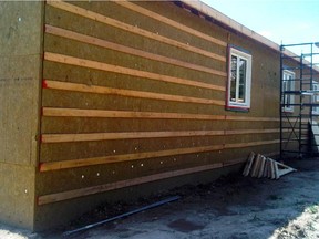 This Canadian-made rigid stone wool insulation is being applied to boost wall performance. It's dense enough to support strapping and siding.