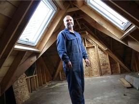 Steve Maxwell stands in the attic of a tiny home he's building. Skylights that open, a steep roof pitch and spray foam insulation make the space fully usable.