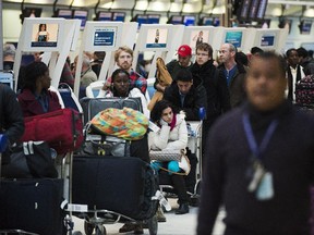 Frustrated passengers line-up during flight delays and cancellations due to extreme cold weather and wind chill at Pearson International Airport in Toronto on Tuesday January 7, 2014.