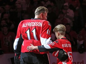 Hugo Alfredsson gives his dad, Daniel Alfredsson, a hug before the leave the ice on the day the Ottawa Senators signed him to a one day contract so he could retire as a Senator.  Assignment - 119185  Photo taken at 19:47 on December 4. (Wayne Cuddington/ Ottawa Citizen)