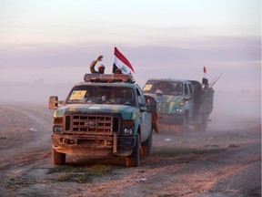 Members of Iraq's Popular Mobilisation units drive on the outskirts of the Iraqi town of Ad-Dawr, on March 6, 2015, during a military operation to retake the Tikrit area from the Islamic State (IS) group.