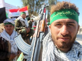 A volunteer Shiite fighter, a member of what is known as the Popular Mobilisation units, gathers in the city of Samarra on March 5, 2015, ahead of moving into Tikrit. Some 30,000 Iraqi security forces members and allied fighters launched an operation to retake Tikrit, the largest of its kind since Islamic State (IS) group forces overran swathes of territory last June.