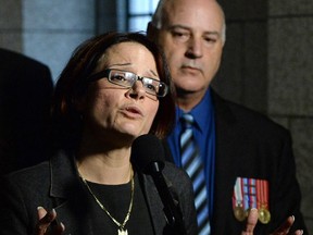 Jenifer Migneault speaks to reporters on Parliament Hill in Ottawa on Wednesday, June 4, 2014, regarding the issues of caregivers helping veterans with PTSD. Her husband and veteran Claude Rainville stands at her side.