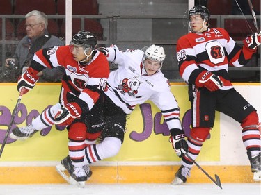 Jeremiah Addison, left, and Sam Studnicka, right, of the Ottawa 67's hit Blake Siebenaler of the Niagara IceDogs during second period OHL action.