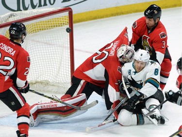San Jose Sharks' Joe Pavelski (8) slams into Ottawa Senators goalie Andrew Hammond as his shot makes its way into the net for a second period goal.