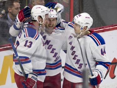 New York Rangers left wing Tanner Glass, centre, is congratulated on his second period goal by teammates Kevin Hayes, left, and Matt Hunwick during NHL action.