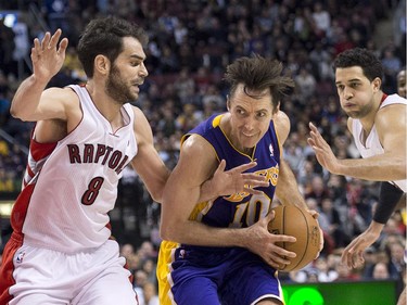 Los Angeles Lakers guard Steve Nash, centre, drives the middle past Toronto Raptors, guard Jose Calderon, left, and Raptors forward Landry Fields, right, during second half NBA basketball action in Toronto on Sunday, January 20, 2013.