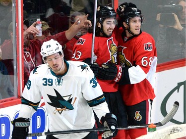 Ottawa Senators' Mika Zibanejad, centre, celebrates a first period goal with teammate Mike Hoffman as San Jose Sharks' Logan Couture (39) skates away during first period NHL hockey action.
