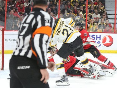 Loui Ericsson of the Boston Bruins scores on Craig Anderson and Cody Ceci of the Ottawa Senators during second period NHL action.