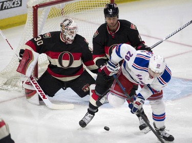 New York Rangers left wing Chris Kreider, right, tries to deflect the puck past Ottawa Senators goalie Andrew Hammond, left, under pressure from defenceman Marc Methot during second period NHL action.