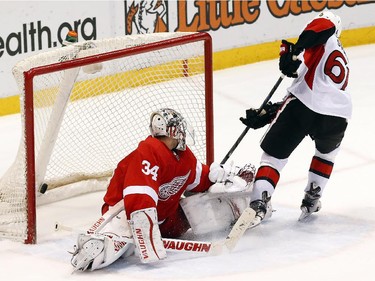 Ottawa Senators' Mark Stone (61) scores on Detroit Red Wings goalie Petr Mrazek (34) in overtime shootout during an NHL hockey game in Detroit Tuesday, March 31, 2015. Ottawa won 2-1 in a shootout.