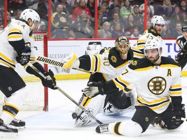Milan Michalek (not in picture) of the Ottawa Senators scores on Patrice Bergeron, right, goalie Tuukka Rask and Dennis Seidenberg, left, of the Boston Bruins during first period NHL action.
