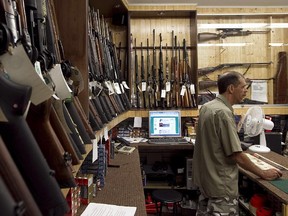 Claude Fortin with rifles and shotguns at his B & L Sports hunting and fishing store in Montreal in 2011.